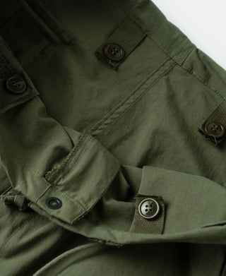 Olive trousers with buttoned flap pockets and seam detail at waistband area