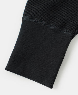 Black ribbed knit sleeve cuff on a thermal waffle knit long-sleeve shirt