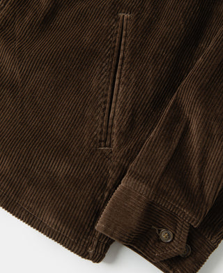 Brown corduroy jacket sleeve cuff with button and stitched placket detail.
