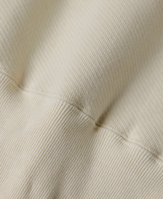 Apricot fleece sweatshirt ribbed hem and shoulder seam close-up