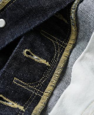 Indigo selvedge denim jeans with curved yellow topstitching and pocket seam detail