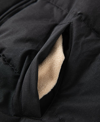 Black padded vest pocket opening with light tan sherpa lining