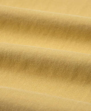 Yellow henley T-shirt fabric close-up showing fine knit texture