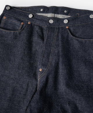 Indigo denim jeans waistband close-up with metal buttons and belt loops