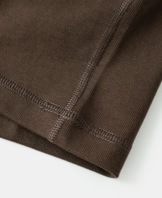 Coffee-brown henley shirt hem stitching and reinforced side seam close-up
