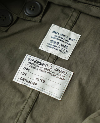 Olive parka interior label with experimental sample information