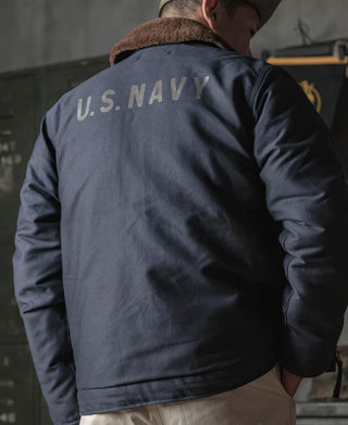 Navy N-1 deck jacket back view with “U.S. NAVY” stencil graphic and shearling collar