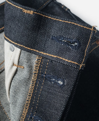 Indigo denim jeans with interior waistband label patch and contrast stitching