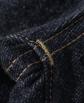 Indigo denim fabric close-up with dense weave and contrast yellow stitch lines