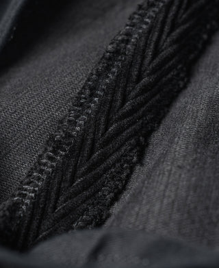 Black fabric panel with reinforced stitching along seam detail.