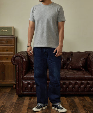 Gray crewneck athletic T-shirt with short sleeves, paired with dark jeans