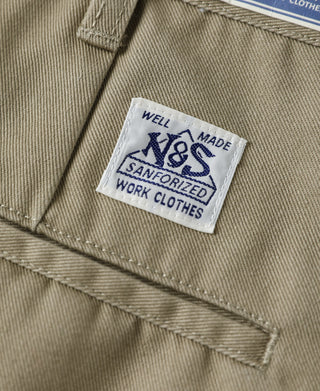 Khaki work pants front with woven “Well Made” label and stitch line