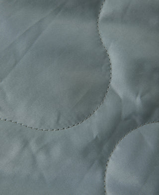 Olive fabric close-up with curved pocket opening and visible seam stitching