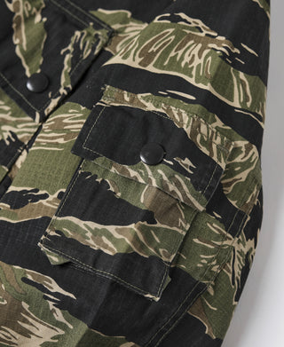 Camo jacket pocket flaps with dark buttons and tiger stripe camo paneling.
