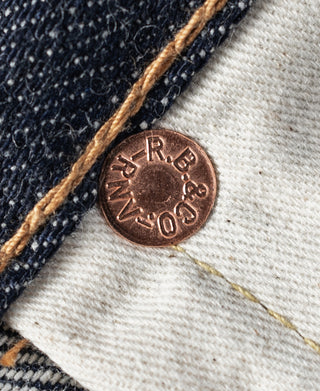 Denim coin pocket rivet with stamped metal logo and tan stitching