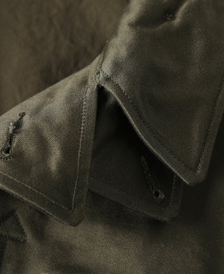 Olive field jacket chest pocket flap with buttonhole and bartack stitching