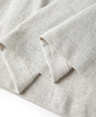 Oatmeal T-shirt sleeve cuff and hem stitching close-up.