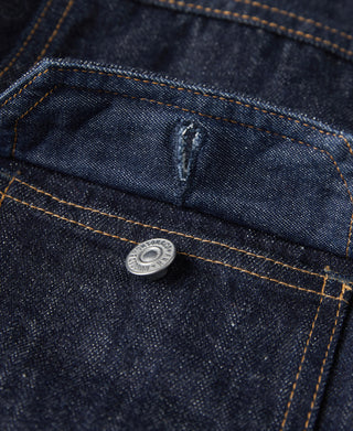 Denim jacket chest pocket area with snap button and contrast orange stitching