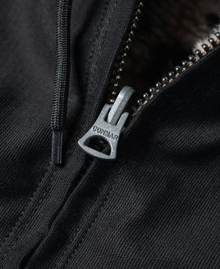 Black zipper pull with metal pull tab on the deck jacket front