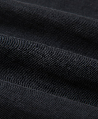 Black cotton T-shirt fabric close-up with fine textured knit
