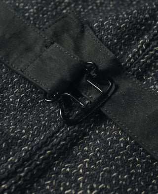 Metal buckle and fastening tab on dark salt-and-pepper wool