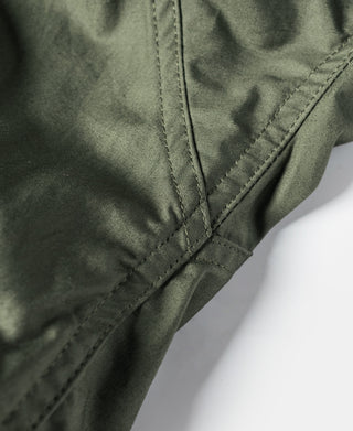 Olive M-65 parka side seam and diagonal stitched reinforcement detail