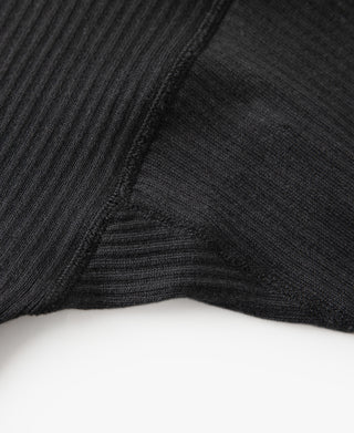 Black ribbed long-sleeve shirt cuff seam with textured knit surface