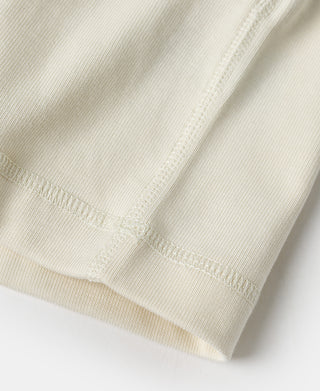Cuff and hem stitching detail on light cream henley shirt sleeve