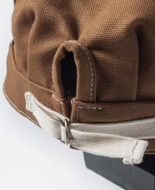 Ginger duck canvas cap close-up: ear flap, stitched edge, and metal fastener
