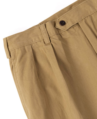 Yellow chino trousers close-up of front pleats and buttoned waistband