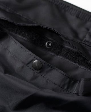 Black nylon helmet bag with snap closure on front pocket and dark lining