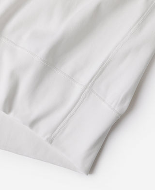 White henley shirt hem with reinforced stitching along the lower edge