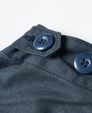 Navy shorts waistband and pocket button close-up with fabric texture