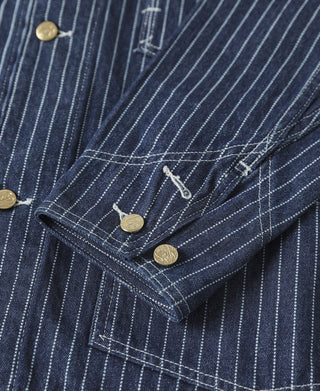 Indigo pinstripe work coat sleeve pocket area with flap, stitching, and brass buttons