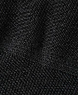 Black wool sweater knit close-up with fine ribbing and seam lines