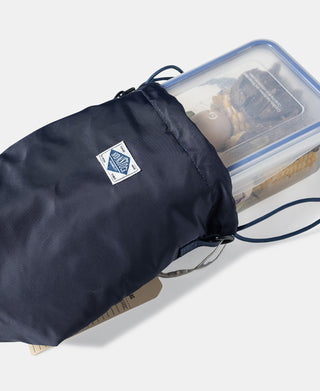 Navy chalk bag partially open, showing contents inside a clear storage case