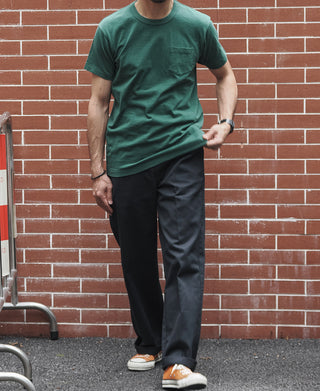 Green crew-neck pocket T-shirt worn with dark pants