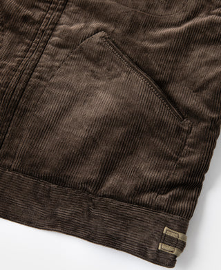 Brown corduroy cossack jacket hem with small brand patch label
