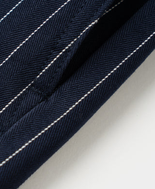 Navy pinstripe fabric close-up with stitched seam and folded edge