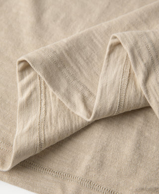 Light tan T-shirt sleeve cuff and hem stitching close-up