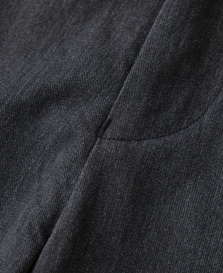 Dark gray trouser leg with front pleat seam and curved pocket opening