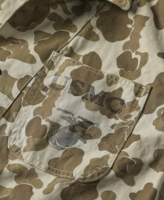 Camo jacket side seam detail with stitched flap pocket and button closure.