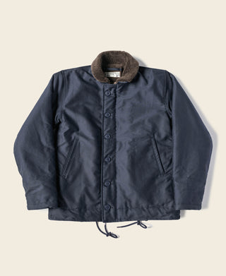 Navy deck jacket with dark fur collar, button front, and two chest pockets