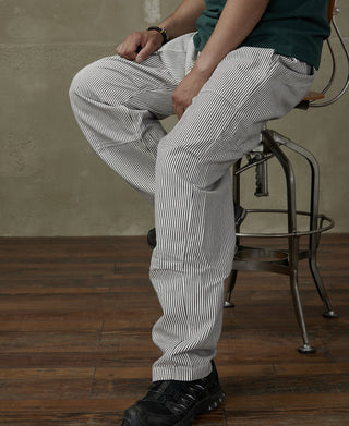 Striped loose pants with cuffed hems and side pocket, vertical dark-and-white stripes