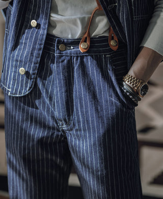 Indigo pinstriped work pants with button waist, belt loops, and pleated front