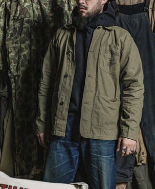 Olive USMC utility jacket worn by a man, button front and chest pocket