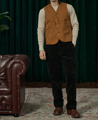 Black corduroy work pants on model, straight leg with belt loops and button front