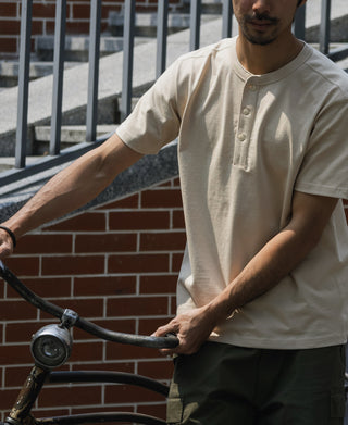 Men’s apricot henley T-shirt on model, three-button placket and short sleeves