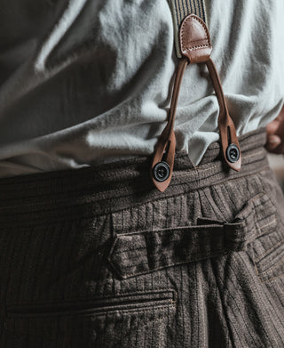 Brown pinstripe pants waistband with buttoned suspender tabs and gathered waist