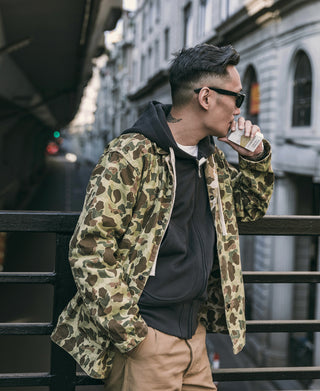 Camouflage duck hunter camo jacket worn on model, hooded sweatshirt underneath